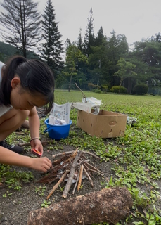 写真：試行錯誤しながら火起こしをする留学生